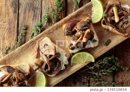 Sandwiches with baked mushrooms on an old wooden table. Sandwiches with baked mushrooms on an old wooden table. 139510658