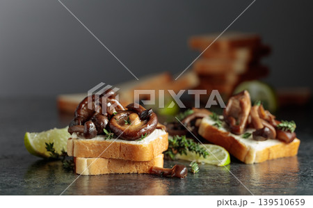 Sandwiches with cream cheese, shiitake and shimeji mushrooms, lime wedges and sprigs of thyme. Sandwiches with cream cheese, shiitake and shimeji mushrooms, lime wedges and sprigs of thyme. 139510659