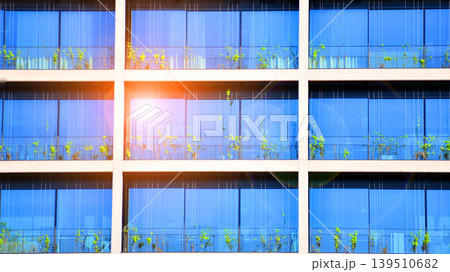 Sustainable glass office building with trees for reducing carbon dioxide. Eco-friendly building in modern city. Office with green environment. Corporate building reduce CO2. 139510682