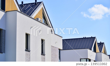 Terraced family homes in newly developed housing estate. The real estate market in the suburbs. New single family houses in a new development area. Residential homes with modern facade.  139511002