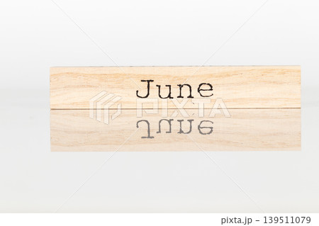 a wooden cube with the inscription June on a white background a wooden cube with the inscription June on a white background 139511079