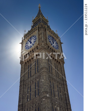 Big Ben Clock Tower in London Against Clear Blue Sky With Sun Backlight and Gothic Detail Big Ben Clock Tower in London Against Clear Blue Sky With Sun Backlight and Gothic Detail 139511224