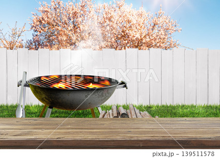 summer time in backyard garden with grill BBQ, wooden table, blurred background 139511578