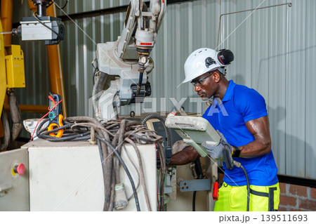 Black Male 20-30s Engineer Inspecting Robotic Arm Black Male 20-30s Engineer Inspecting Robotic Arm 139511693
