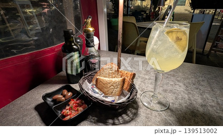 Local limoncello spritz and appetizer toast with fresh tomato salsa and olives 139513002