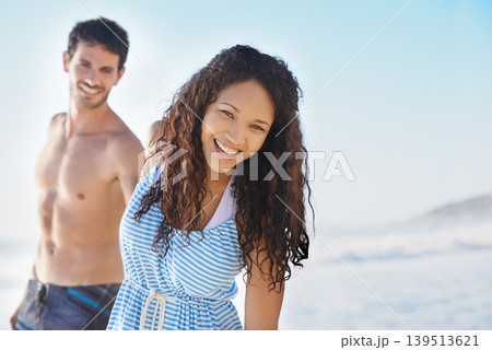 Happy couple, portrait and holding hands on beach for bonding, summer holiday or outdoor weekend together. Man and woman smile on ocean water with blue sky for fun day in the sun on mockup space 139513621