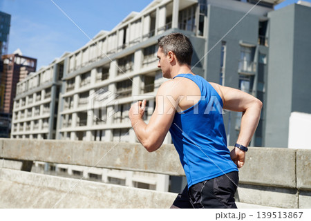 Man, fitness and running on road in city for workout, exercise or outdoor cardio with buildings. Active male person, athlete or runner in training or practice for health and wellness in an urban town Man, fitness and running on road in city for workout, exercise or outdoor cardio with buildings. Active male person, athlete or runner in training or practice for health and wellness in an urban town 139513867