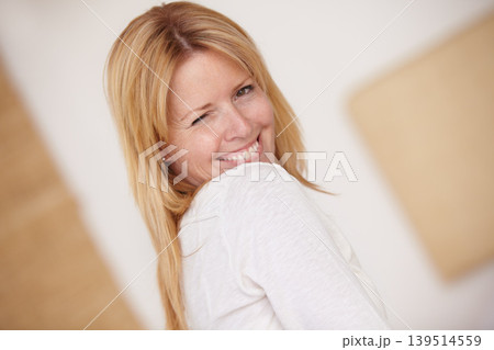 Happy woman, smiling and playful with wink, face and portrait in home, natural beauty and alone. Female, beautiful and thinking with idea, mature person and cheerful lady in house or blonde hair Happy woman, smiling and playful with wink, face and portrait in home, natural beauty and alone. Female, beautiful and thinking with idea, mature person and cheerful lady in house or blonde hair 139514559