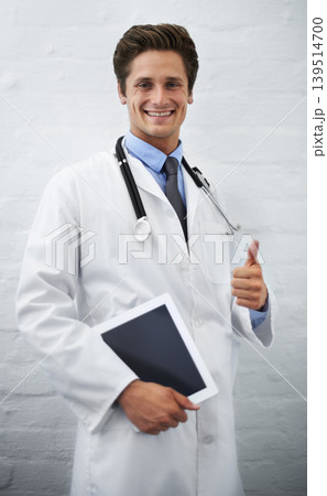 Happy man, portrait and doctor with thumbs up and tablet for success in healthcare on a white studio background. Male person, surgeon or medical professional smile with like emoji, yes sign or OK 139514700