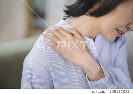 肩を押さえる40代の女性の手元 肩を押さえる40代の女性の手元 139515021