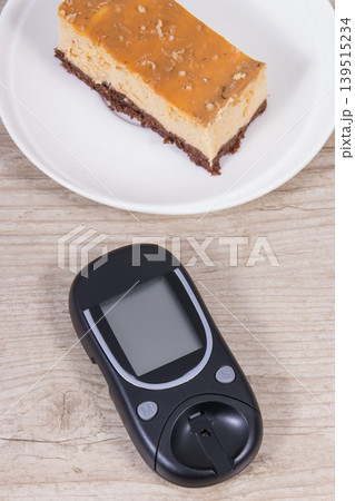 Glucometer for measuring sugar level and sweet cheesecake. Nutrition during diabetes Glucometer for measuring sugar level and sweet cheesecake. Nutrition during diabetes 139515234