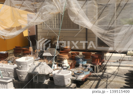 懐かしさを感じる小屋と石の置物と植木鉢 懐かしさを感じる小屋と石の置物と植木鉢 139515400
