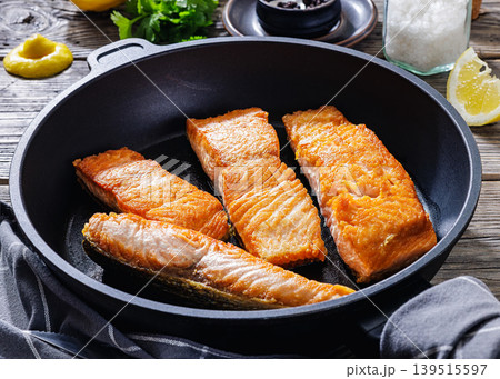 Pan-seared salmon fillets on a skillet, close-up Pan-seared salmon fillets on a skillet, close-up 139515597