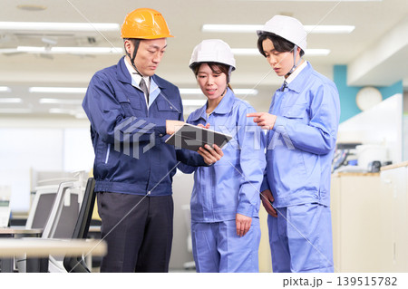 タブレットを見ながら打ち合わせを行う施工管理チーム 139515782