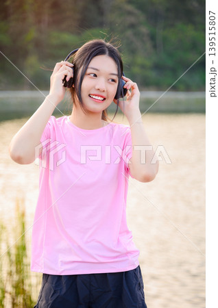 attractive asian woman healthy jogging exercise with headphones in park outdoor attractive asian woman healthy jogging exercise with headphones in park outdoor 139515807