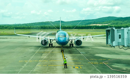 An Airplane Of Vietnam Airlines Connecting To Jet Bridge For Passenger Boarding At Phu Quoc International Airport, Vietnam. An Airplane Of Vietnam Airlines Connecting To Jet Bridge For Passenger Boarding At Phu Quoc International Airport, Vietnam. 139516359