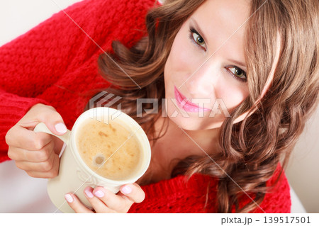 Girl red sweater holds mug with coffee Girl red sweater holds mug with coffee 139517501