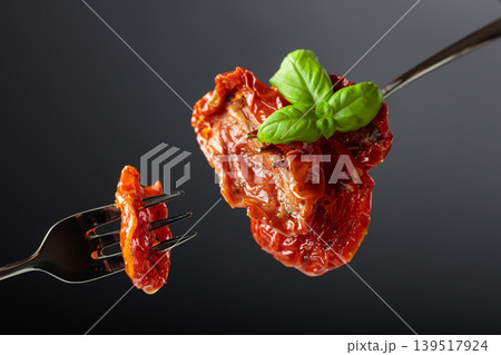 Sun dried tomatoes in olive oil with green basil. Sun dried tomatoes in olive oil with green basil. 139517924