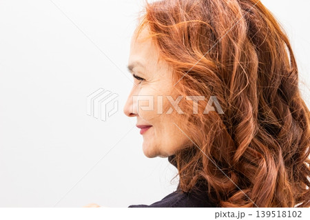 Profile portrait of successful 60 year old Asian woman with copper hair. Mature lady posing for headshot. Natural beauty, healthy skin and empowerment of aging, lifestyle concept. 139518102