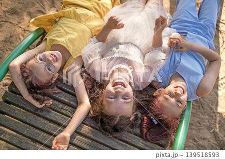 Beautiful happy Girls are lying on sun beds on the beach by the sea. View from above 139518593
