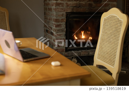 Fireplace laptop and chair in cozy home interior Fireplace laptop and chair in cozy home interior 139518619