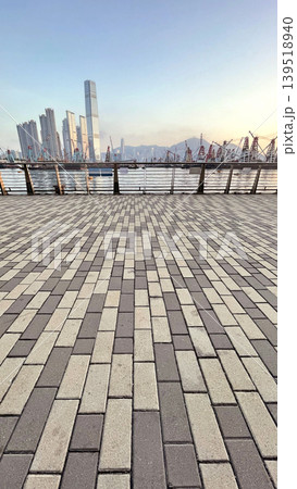 Hong Kong skyline with construction cranes and waterfront promenade at sunrise Hong Kong skyline with construction cranes and waterfront promenade at sunrise 139518940