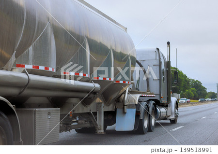 Large tank truck travels along highway with other vehicles in 139518991