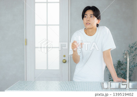 グラスに入った水を飲む男性 139519402