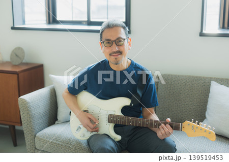 ソファーでギターを弾くシニア男性 ソファーでギターを弾くシニア男性 139519453