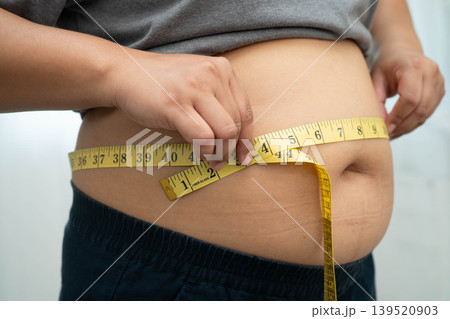 Asian woman with fat belly big size overweight and obesity with measure tape. Asian woman with fat belly big size overweight and obesity with measure tape. 139520903