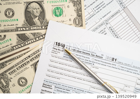 Tax form 1040 U.S. Individual Income Tax Return with dollar banknotes money. Tax form 1040 U.S. Individual Income Tax Return with dollar banknotes money. 139520949