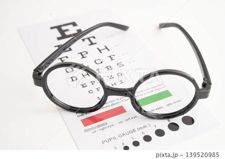Glasses on eye testing exam chart to check eyesight accuracy of reading. 139520985