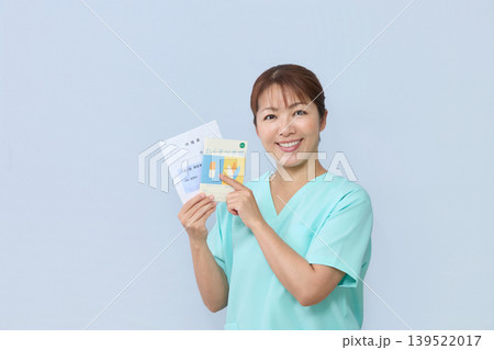 お薬手帳を案内する女性医療スタッフ 139522017