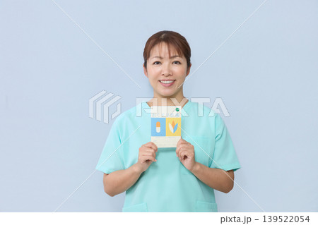 お薬手帳を案内する女性医療スタッフ 139522054