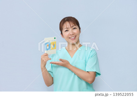 お薬手帳を案内する女性医療スタッフ 139522055