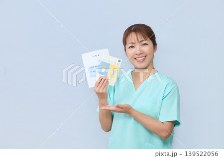 お薬手帳を案内する女性医療スタッフ 139522056