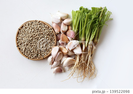 Garlic cloves, coriander roots, and white peppercorns, key ingredients for a classic Thai spice paste Garlic cloves, coriander roots, and white peppercorns, key ingredients for a classic Thai spice paste 139522098