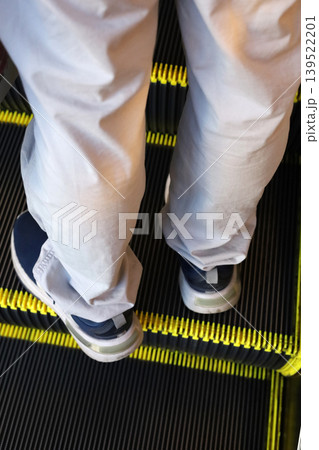 Person standing on escalator step 139522201