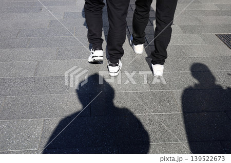 Pedestrians walking with long shadows 139522673
