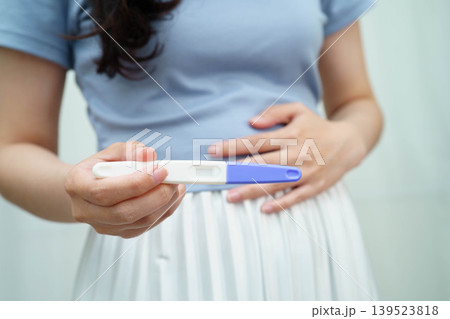 Asian holding pregnancy test for female of ovulation day, fetus, maternity, childbirth, birth control. Asian holding pregnancy test for female of ovulation day, fetus, maternity, childbirth, birth control. 139523818