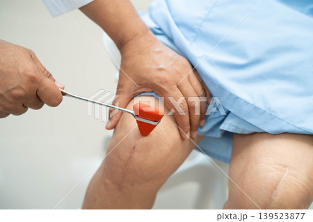 Asian doctor knock on knee reflex nerve for check and treatment senior patient in hospital. Asian doctor knock on knee reflex nerve for check and treatment senior patient in hospital. 139523877