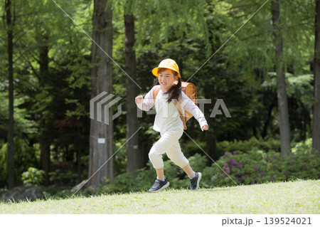 新緑の中ランドセルで走る登校する笑顔の女の子 黄色い帽子を被った1年生の新生活と通学や学校、学資保険 新緑の中ランドセルで走る登校する笑顔の女の子 黄色い帽子を被った1年生の新生活と通学や学校、学資保険 139524021