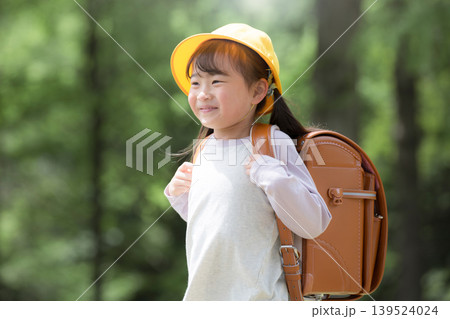 新緑の中ランドセルで走る登校する笑顔の女の子 黄色い帽子を被った1年生の新生活と通学や学校、学資保険 新緑の中ランドセルで走る登校する笑顔の女の子 黄色い帽子を被った1年生の新生活と通学や学校、学資保険 139524024
