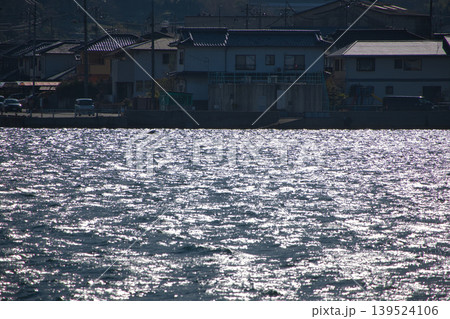 冬の尾道水道に反射する太陽光と穏やかな波。港町の日常を感じる瀬戸内の風景 冬の尾道水道に反射する太陽光と穏やかな波。港町の日常を感じる瀬戸内の風景 139524106