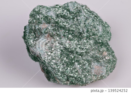 Vivid mineral detail. Highresolution photograph capturing luminous green mineral with glistening mica fragments and tiny surface cavities for educational and artistic purposes Vivid mineral detail. Highresolution photograph capturing luminous green mineral with glistening mica fragments and tiny surface cavities for educational and artistic purposes 139524252