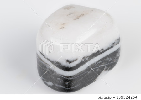 Closeup of patterned mineral. Polished siliceous argillite displaying banding and gloss. Closeup of polished striped rock showing mineral layers and reflective surface 139524254