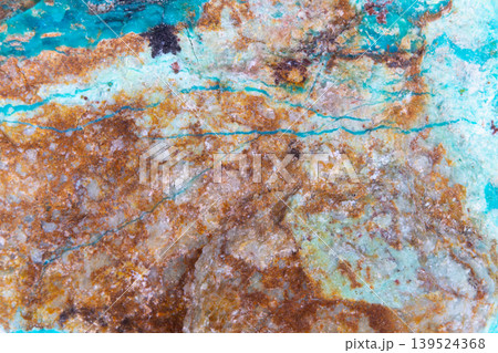 Mineral terrain with turquoise veins. Rugged earthy mineral terrain with vibrant turquoise streaks and textured oxidized sediment surface suitable for ecofriendly interiors 139524368