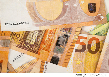 Inspecting currency for authenticity details. Detailed examination of euro banknotes emphasizing security elements like holographic features and microprint patterns 139524397