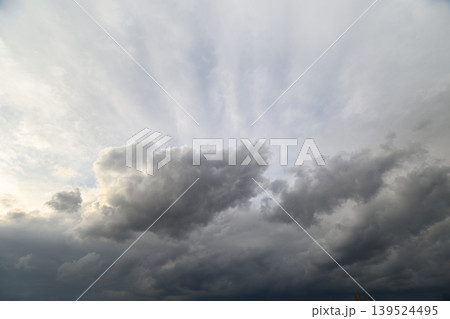 Stormy sky ahead. Dark tumultuous clouds break with rays amid brewing storm. Dramatic and moody weather scene featuring swirling storm clouds and sunlight peeking through Stormy sky ahead. Dark tumultuous clouds break with rays amid brewing storm. Dramatic and moody weather scene featuring swirling storm clouds and sunlight peeking through 139524495