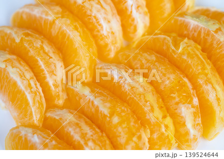 Closeup vibrant orange segments offering quick energy boost, natural sugars visible, high contrast styling, athletic lifestyle suggestion for post run refreshment 139524644